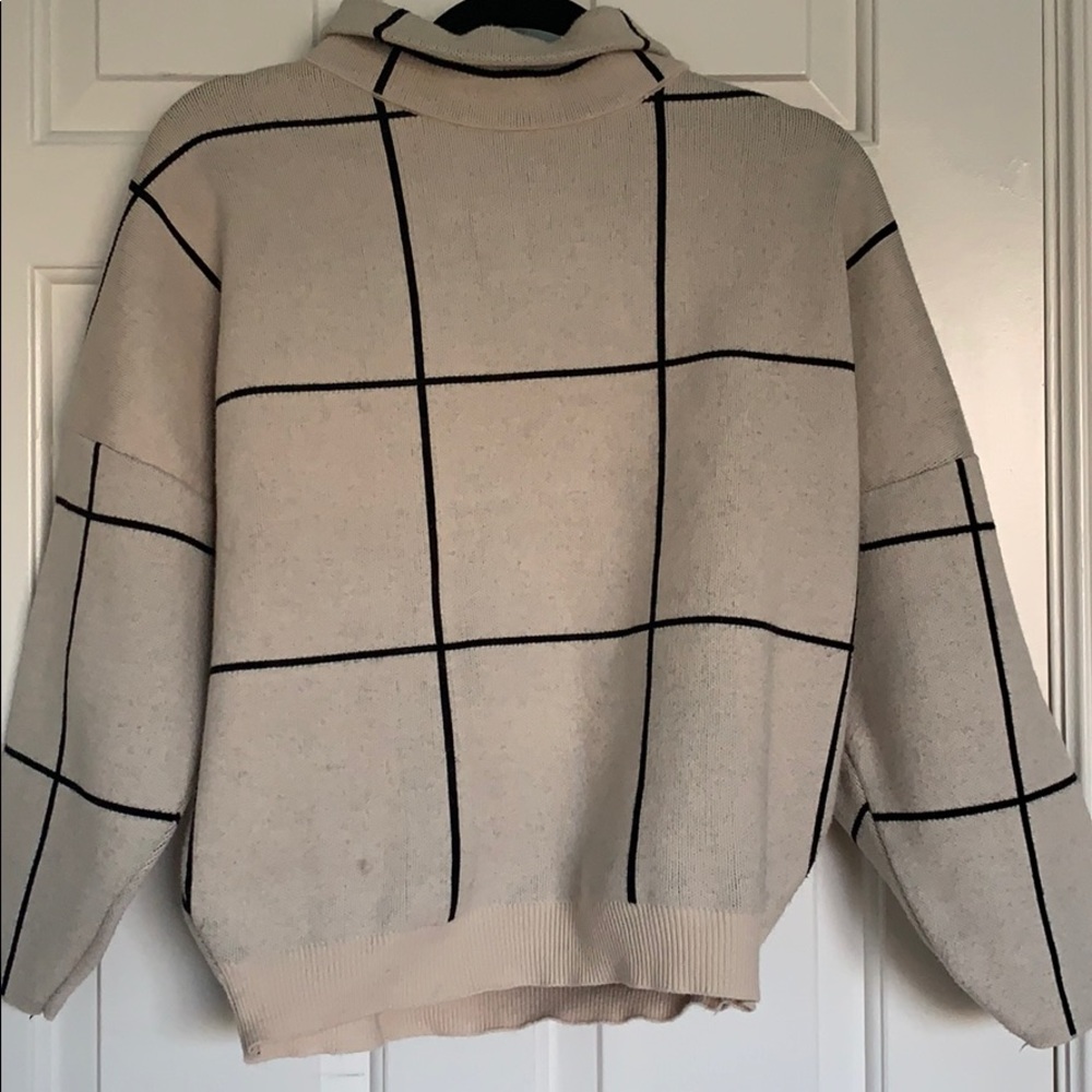 Plaid cream and black pullover sweater.